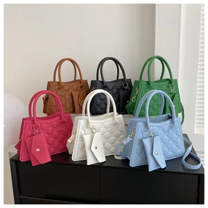 Multiple colors of quilted crossbody bags with matching mini coin purses on a black table