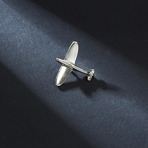 Polished silver airplane brooch with vintage propeller design on navy texture