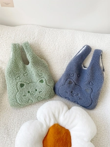 Close-up of cute lamb wool handbags with cartoon embroidery and heart patterns