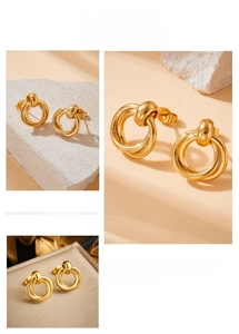 Detailed close-up of gold-plated geometric interlocking knot earrings in a luxe setting