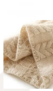 Close-up of beige cashmere cable knit texture with detailed overlock stitching details