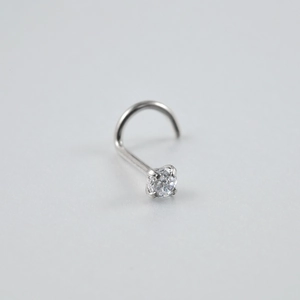 Macro shot of silver G23 titanium nose stud with clear round cubic zirconia crystal