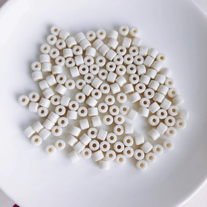 Close-up of white cylindrical acrylic spacer beads for DIY jewelry and phone charms