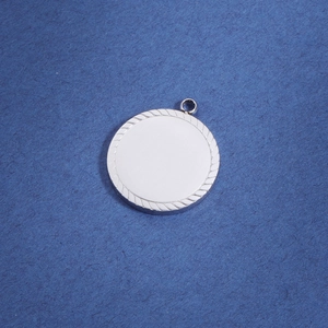 Detailed view of silver round metal pendant with rope edge texture for DIY engraving