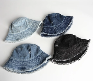Close-up of distressed denim bucket hats featuring frayed edges and vintage ripped details
