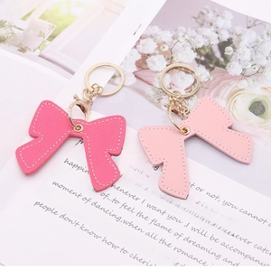 Cute pink leather bow keychains in light and dark shades with elegant gold hardware