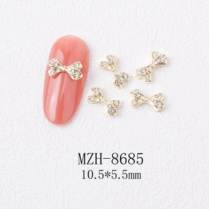 Detailed 10.5x5.5mm golden bow alloy nail charm with transparent crystals for manicure