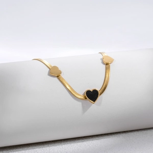 Minimalist gold snake chain bracelet with black and gold heart pendants for women