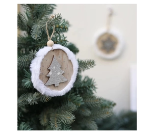 Detail of wooden Christmas ornament with white fur trim and silver glitter tree hanging on a pine