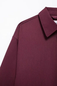 Detail of burgundy turn-down collar and fine twill texture with precise stitching