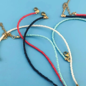 Detail view of colorful seed bead necklaces with freshwater pearls and gold lobster clasps