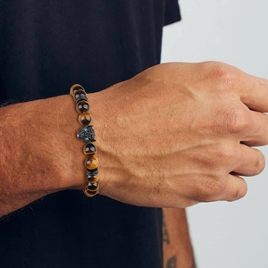 Close-up of a men's tiger eye beaded bracelet featuring a zircon leopard head on the wrist