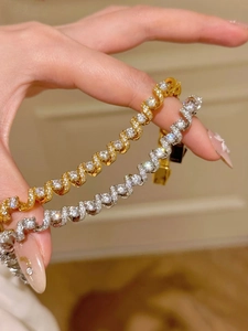 Detail of 18K gold and silver plated X-shaped chain bracelets with micro-pave zircons