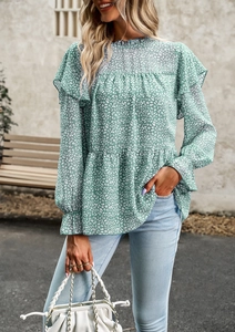 Outdoor street style shot of a green floral chiffon long sleeve blouse with ruffled details