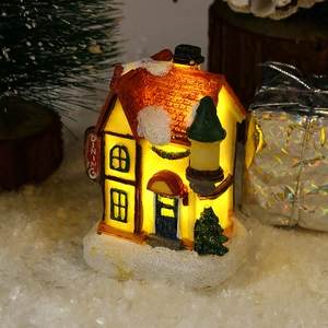 Close-up of lighted resin Christmas snow house with dining sign and warm LED glow