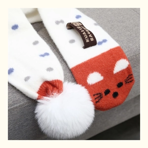 Detail of white knit scarf with fox design, pom-pom and blue polka dots for kids