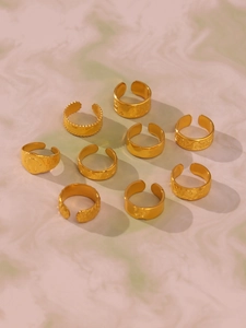 Detail view of nine-piece gold-plated stainless steel rings with minimalist patterns