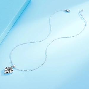 Silver minimalist heart pendant necklace on blue background with gift box