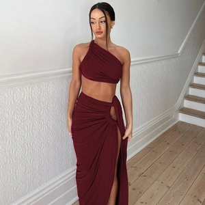 Close-up of wine red two-piece set featuring pleated fabric and high side slit skirt