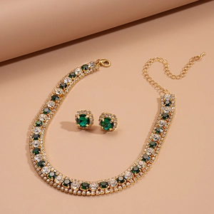 Luxurious gold necklace and earrings set featuring emerald green gems and zircon accents