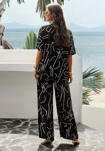 Detail showing the back view of a black short-sleeve top and wide-leg pants with white lines