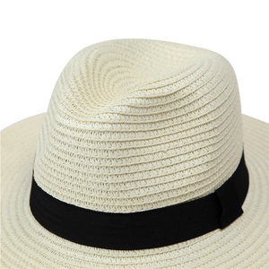 Close-up of beige woven straw Panama hat with classic black grosgrain ribbon detail