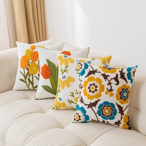 Detailed close-up of 3D towel embroidered floral patterns on square cushion covers