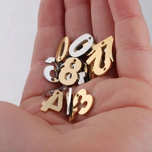 Macro shot of assorted golden and silver number pendants held in a person's palm