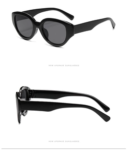 Detail view showing cat-eye frame and thick temples of black oval sunglasses