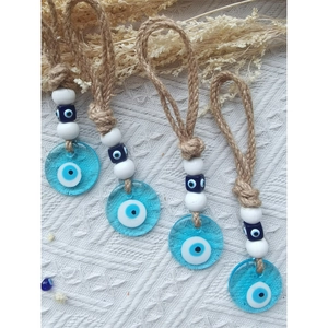 Macro detail of four Turkish Evil Eye wall hangings with glass beads and hemp rope