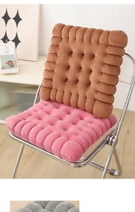Close-up of thick biscuit-shaped cushions in coffee and pink plush fabric on a chair