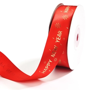 Detail of red Christmas ribbon with golden Happy New Year text and snowflake patterns