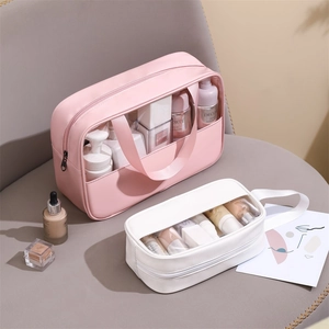 Pink and white waterproof PU PVC toiletry bags with handles on a minimalist chair