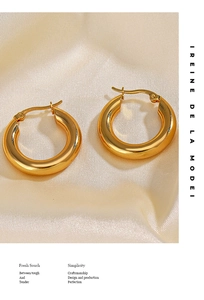 Dettaglio di orecchini a cerchio placcati oro 18K su sfondo in seta beige liscio