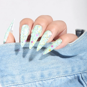 Detailed shot of long stiletto press-on nails with colorful glitter on mint green base