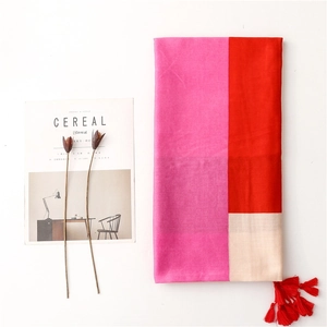 Detail of color-block scarf with pink and red panels featuring a red fringe tassel