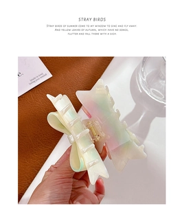 Detail view of large gradient acetate bow hair claw clip with rhinestones held in hand