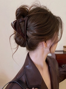 Detail shot of a dark brown triangular acrylic hair claw clip used on hair back