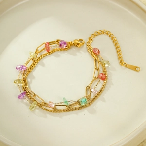 Three-layer gold stainless steel bracelet with colorful crystal stones on white ceramic plate