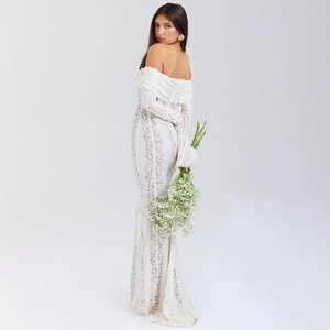 Dettagli dell'elegante abito in pizzo bianco con spalle scoperte e strascico raffinato