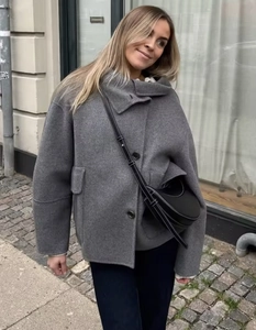 Detail of grey wool blend jacket texture with single-breasted buttons and high neck