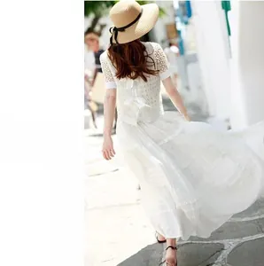 Dettaglio del top bianco in pizzo crochet con fiocco sul retro per le vacanze estive