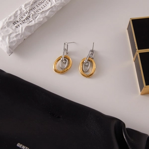Modern two-tone interlocking oval earrings in gold and silver finish with high-end texture