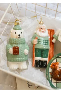 Close-up of ceramic polar bear and Santa ornaments with gold string in a basket