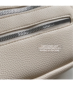 Detailansicht der beigen Bauchtasche aus Leder mit Litschi-Muster und Doppelreißverschluss