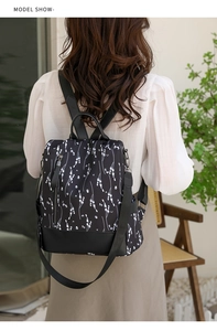 Détail d'un sac à dos floral en nylon avec fermeture antivol au dos porté par un mannequin