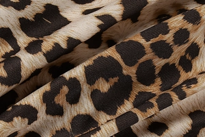 Close-up of leopard print fabric texture showing detailed weave and brown tones