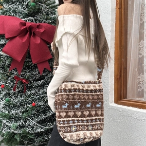 Detail of plush crossbody bucket bag featuring brown heart and animal patterns