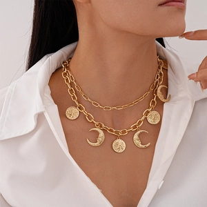 Detail of gold double-layer chain necklace featuring sun and moon relief pendants