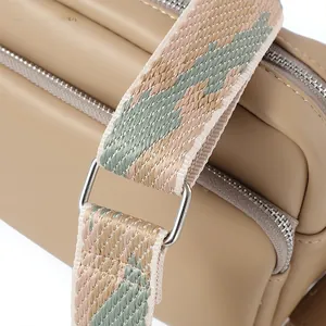 Dettaglio borsa a tracolla kaki con tracolla in tessuto colorato e fibbie argentate